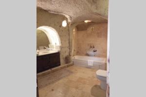 a bathroom with a tub and a toilet and a sink at Fairy Chimney House in Nevsehir