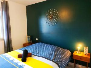 Schlafzimmer mit einem Bett mit blauer Wand in der Unterkunft L'Anne'xe champêtre d'Alex, calme, proche ville in Fontenay-le-Comte