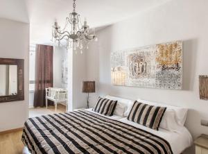 a bedroom with a bed and a chandelier at BCN Rambla Catalunya Apartments in Barcelona