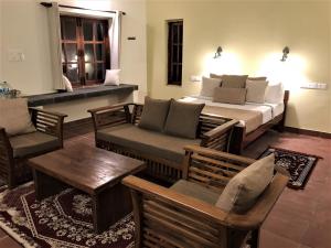 ein Schlafzimmer mit einem Bett, einem Sofa und einem Tisch in der Unterkunft Mandaram villas in Mararikulam