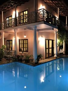 a villa with a swimming pool at night at Mandaram villas in Mararikulam