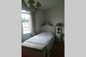 a bedroom with a bed and a lamp and windows at la maison de Caroline in Saint-Valéry-en-Caux