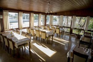 a dining room with tables and chairs and windows at Bodrum Marma Otel in Bodrum City