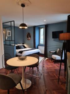 een slaapkamer met een bed en een tafel en stoelen bij LESAGE, au coeur de Vannes in Vannes