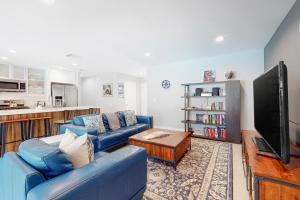 a living room with two blue couches and a tv at Escape To Palm Desert in Palm Desert