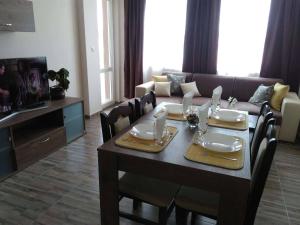 een woonkamer met een tafel en een bank bij Nev Apart New in Velingrad