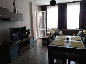 een woonkamer met een bank en een tafel bij Nev Apart New in Velingrad