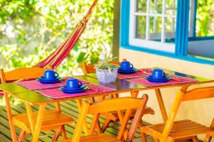 a wooden table with blue cups and saucers on it at Casa do Pescador Camburi in Camburi