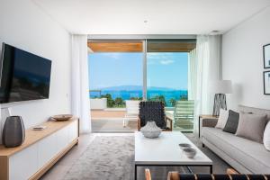 a living room with a couch and a tv at Los Jardines de Abama Suites in Guía de Isora
