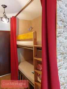 Cette chambre comprend un lit superposé avec un rideau rouge. dans l'établissement La Foux d'Allos IDEAL 4 personnes, à La Foux