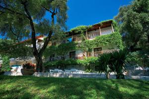 a building with trees and chairs in front of it at Magda's Hotel Apartments in Parga