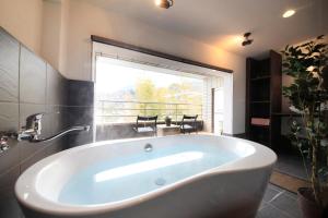 
a bathroom with a tub and a bathtub in it at Merveille Hakone Gora in Hakone
