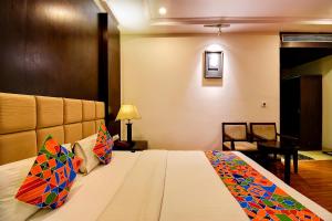 a hotel room with a bed with colorful pillows at FabHotel Suvee Boutique Banashankari in Bangalore