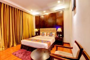 a bedroom with a bed and a table and a chair at Oriva Suvee Boutique Banashankari in Bengaluru