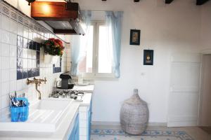 una cucina bianca con lavandino e finestra di La Casina Della Quiete a Casarano