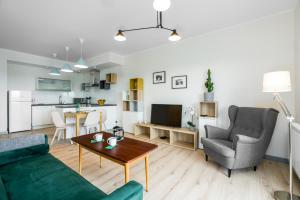 ein Wohnzimmer mit einem grünen Sofa und einem Tisch in der Unterkunft Warta Residence Apartments by Renters in Posen