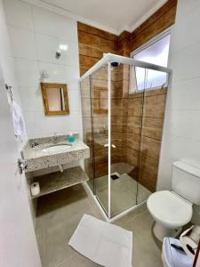 a bathroom with a shower and a toilet and a sink at Residencial 220 Maresias in Maresias