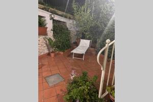 un patio con una silla blanca y algunas plantas en AffIttasi Casa Giuseppe, en Procida