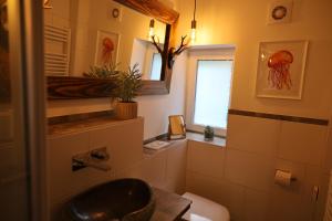łazienka z umywalką, toaletą i oknem w obiekcie Appartement 'Oachkatzl' w mieście Grossvolderberg