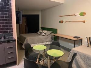 Habitación con 1 cama, 2 mesas y sillas en Apartamento Studio na Beira Mar de Pajuçara - todo reformado, en Maceió