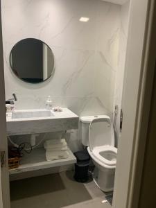 een badkamer met een wastafel, een toilet en een spiegel bij Apartamento Studio na Beira Mar de Pajuçara - todo reformado in Maceió