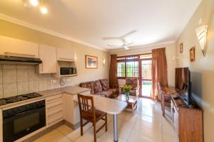 a kitchen and living room with a table and chairs at Shakespeare Court Serviced Apartments in Lusaka