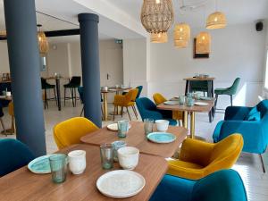 a dining room with a wooden table and chairs at Hôtel La Maison des Dunes in Erdeven
