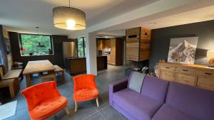 a living room with a purple couch and orange chairs at Chalet de l’Alpette in Valloire +52 photos
