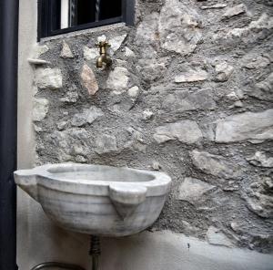 un évier en pierre sur le côté d'un mur en pierre dans l'établissement "Le pietre silenti" antica dimora del 1300', à Nerola