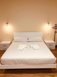 a large white bed with two white towels on it at Casa Maka' in Olbia