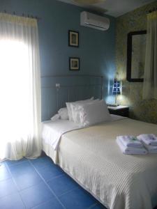 Un dormitorio con una cama blanca y una ventana. en Dominici, en Ammoulianí 40 fotos más