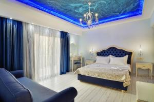 a bedroom with a bed and a blue ceiling at Hotel Parga Princess in Parga