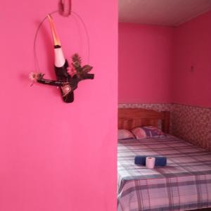 Guaraná da Cláudia في سانتاريم: امرأة معلقة على جدار في غرفة مع سرير