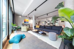 ipartment Darmstadt في دارمشتات: غرفة معيشة بها أريكة زرقاء وبعض النباتات