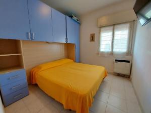 a bedroom with a yellow bed and blue cabinets at Pagoda 4 in Lido di Pomposa +30 photos