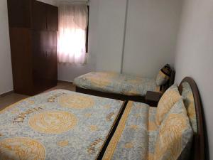 - une chambre avec 2 lits dans une chambre avec une fenêtre dans l'établissement House by the lake, à Pogradec