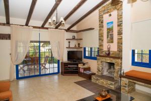 a living room with a fireplace and a tv at Akamas Edge Villas in Polis Chrysochous