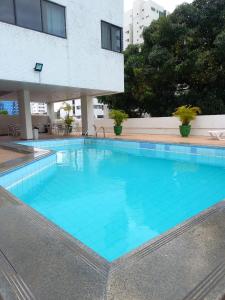勒西菲的住宿－Hotel Nacional Inn Recife Aeroporto，一座大型蓝色游泳池,位于大楼旁边