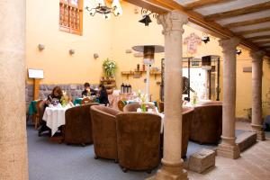 a group of people sitting at tables in a restaurant at Hotel & Mirador Los Apus in Cusco