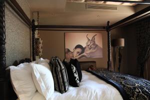 Palala Boutique Game Lodge and Spa في Tom Burke: غرفة نوم مع سرير مع ملصق على الحائط