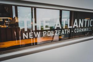 a window with the new paladin new policing commission sign at Polzeath Beach House in Polzeath