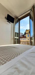 a bedroom with a large window with a tv on the wall at Hotel Mondial in Milan
