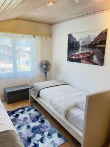 um quarto com uma cama e um quadro na parede em S&P Mountain View Apartment 2 em Wilderswil