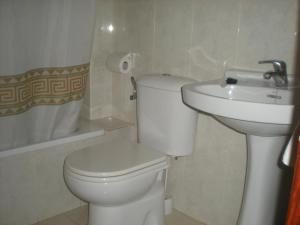 uma casa de banho branca com um WC e um lavatório em Pension Vagalume em Boiro