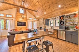 a kitchen and living room with a wooden ceiling at Modern Cabin with Spacious Deck, BBQ, and Pergola! in Broken Bow
