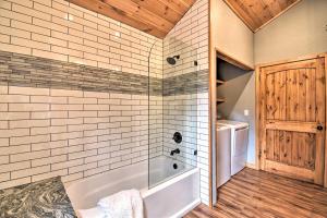 a bathroom with a tub and a washing machine at Modern Broken Bow Cabin Large Deck, BBQ and Pergola in Broken Bow +18 photos