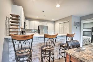 a kitchen with three bar stools and a kitchen island at Lake of the Ozarks Home with Balcony and Grill! in Osage Beach