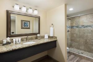 a bathroom with a sink, mirror, and bathtub at The Scottsdale Plaza Resort & Villas in Scottsdale