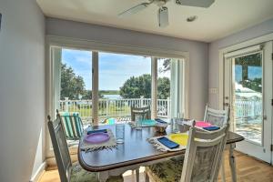 a dining room with a table and chairs and a large window at Waterfront Hampstead Home Dock and Waterway Access! in Hampstead