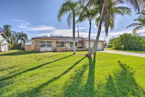 a yard with palm trees in front of a house at Modern Port St Lucie Home with Private Outdoor Oasis in River Park